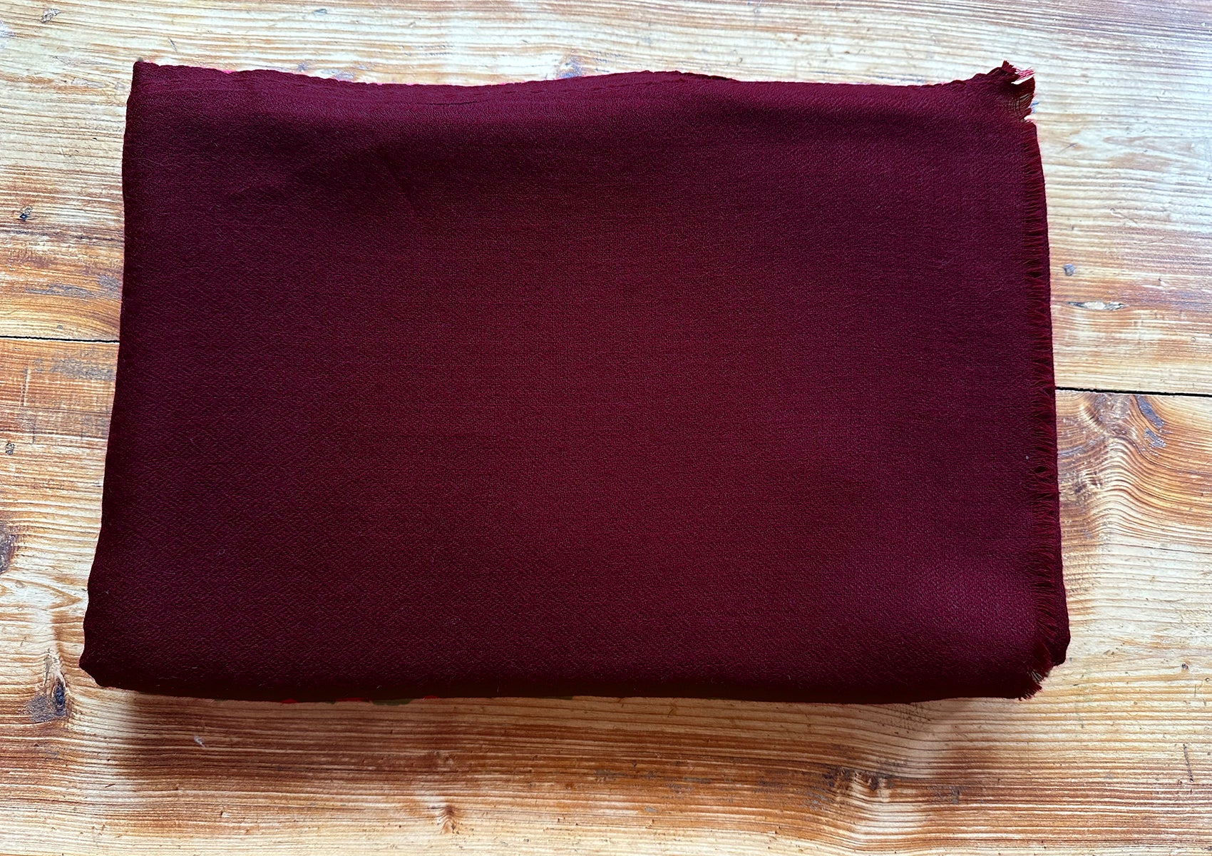 Light burgundy bodhi pashmina meditation shawl, folded to reveal its delicate and lightweight texture.