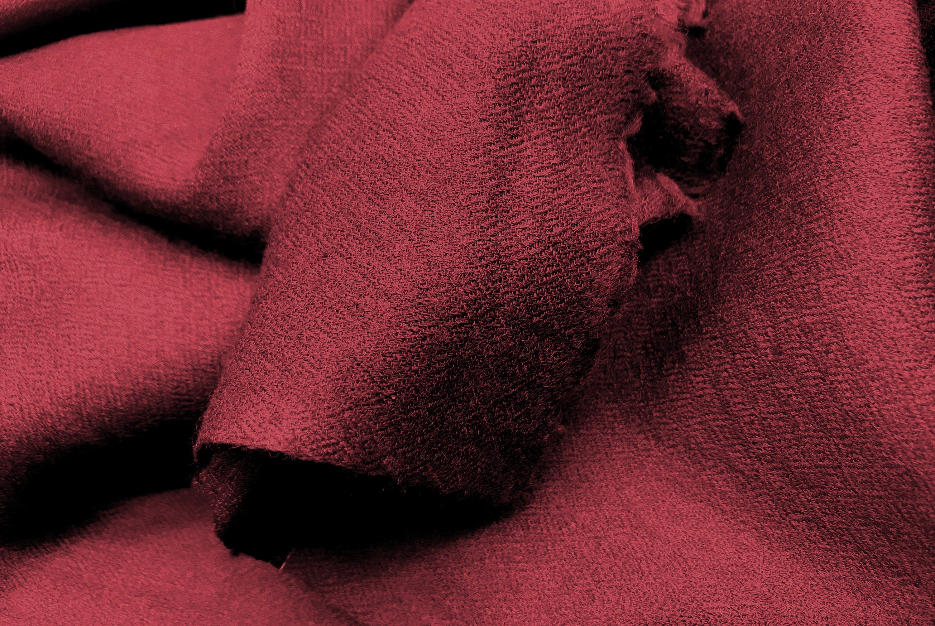 Close-up of maroon yak wool fabric with a soft, textured surface, perfect for cozy blankets and shawls.