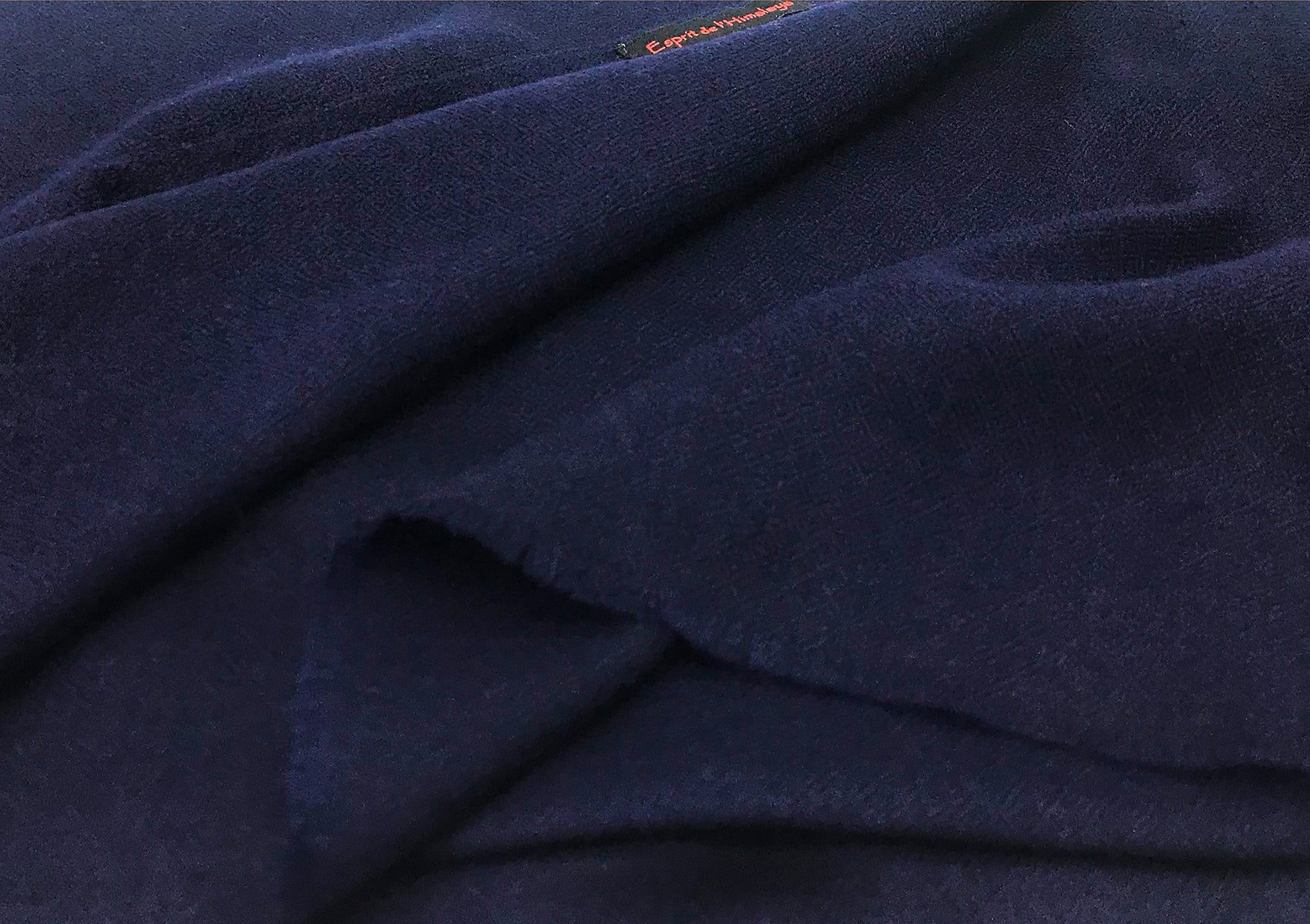 Close-up of the soft texture of a navy blue pashmina cashmere shawl, showcasing its fine weave and subtle details