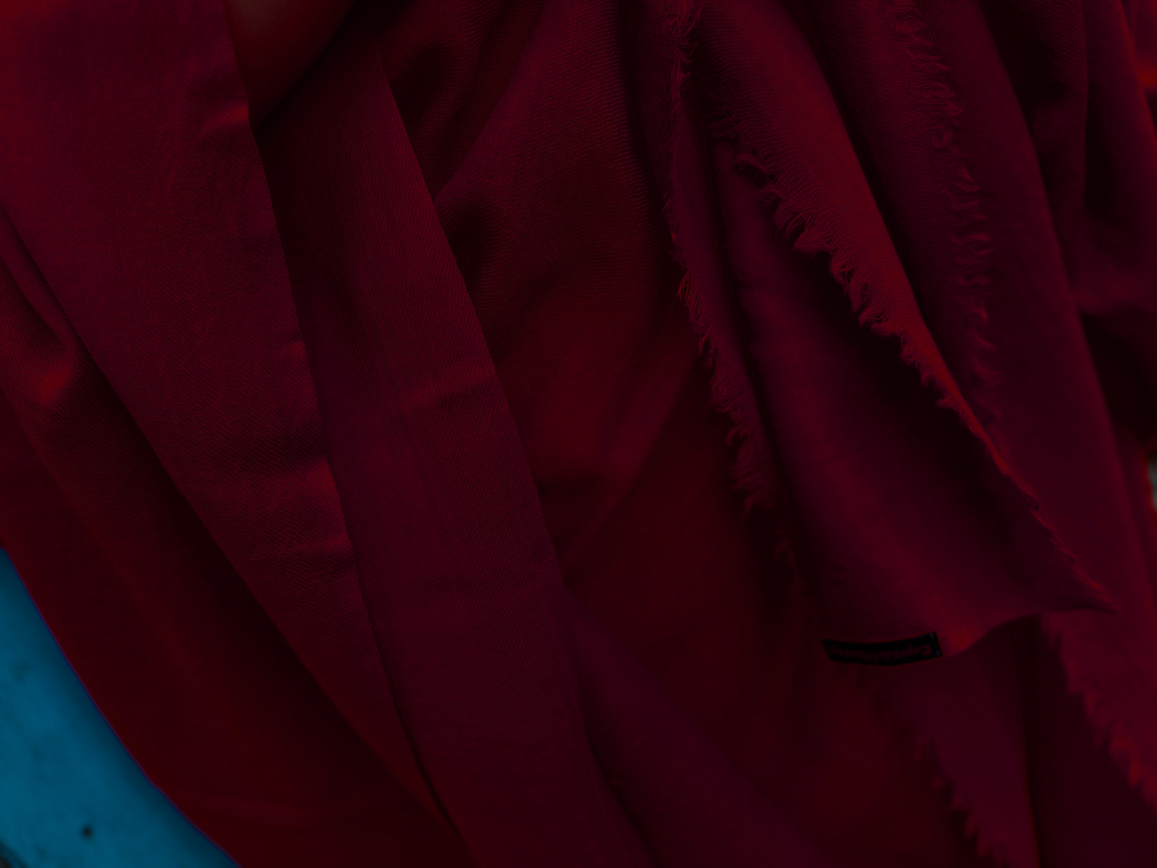 Dark burgundy shawl close-up, focusing on the deep rich color and soft fabric texture.