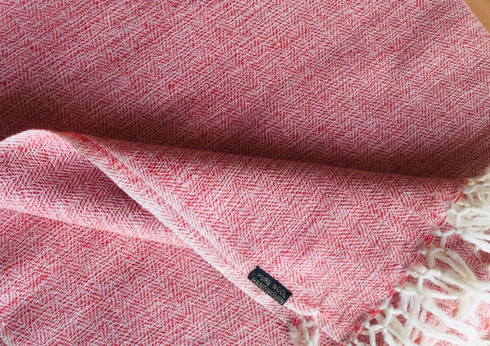 Detailed close-up of a pink shawl with visible fringes, emphasizing the woven details.