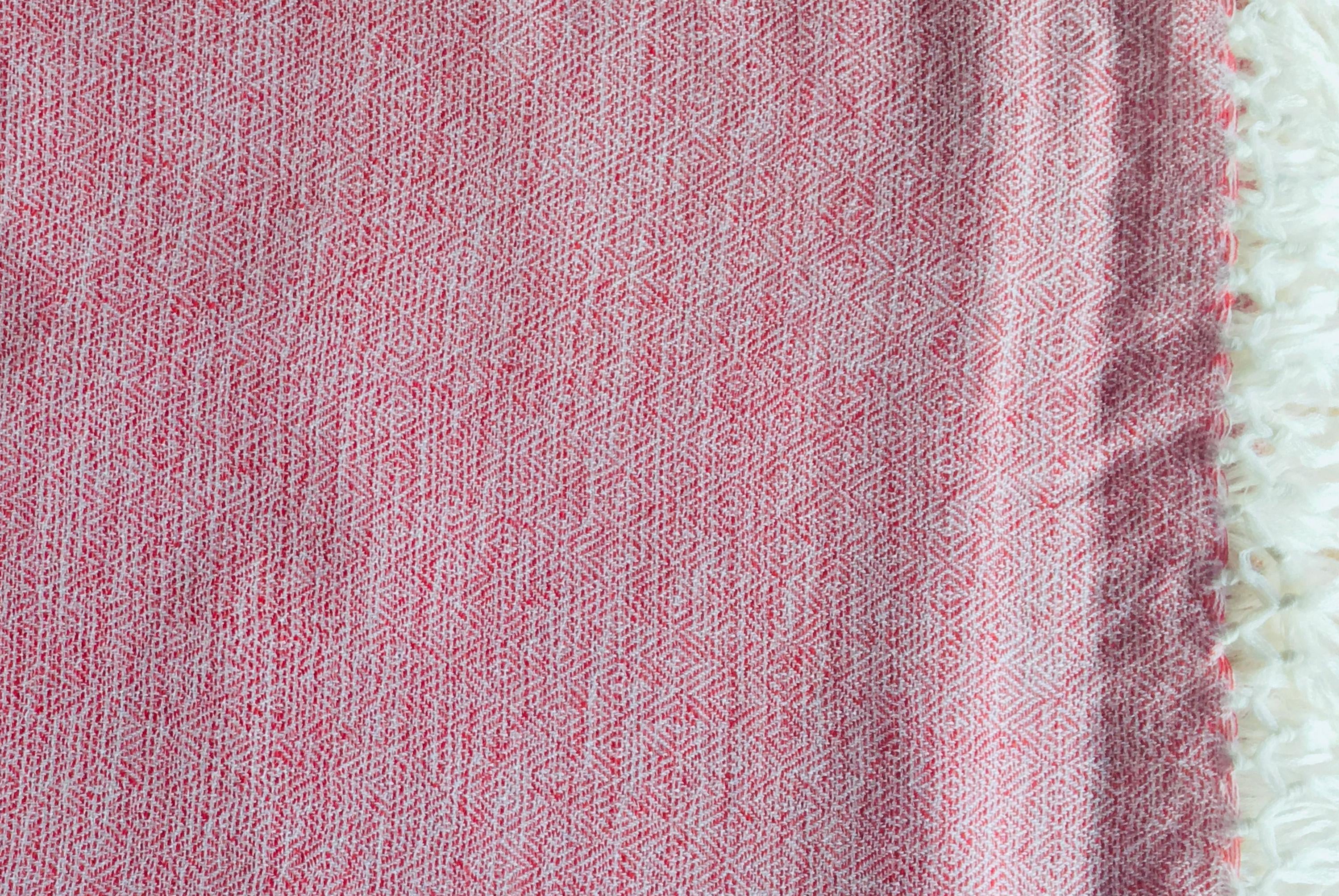 Detailed view of the pink shawl woven texture with a geometric pattern.