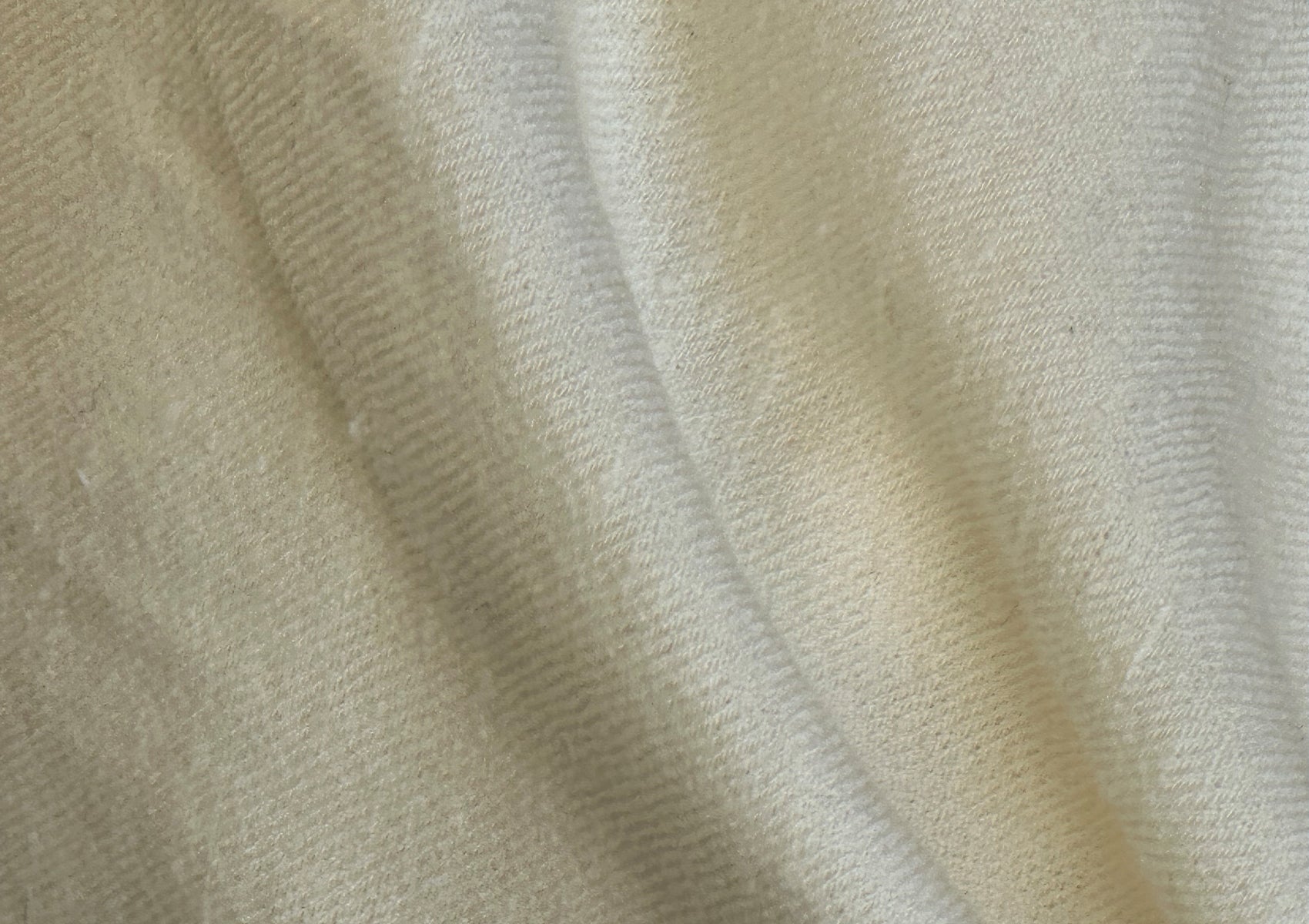 A cream angora shawl gracefully spread, highlighting its smooth and plush texture.