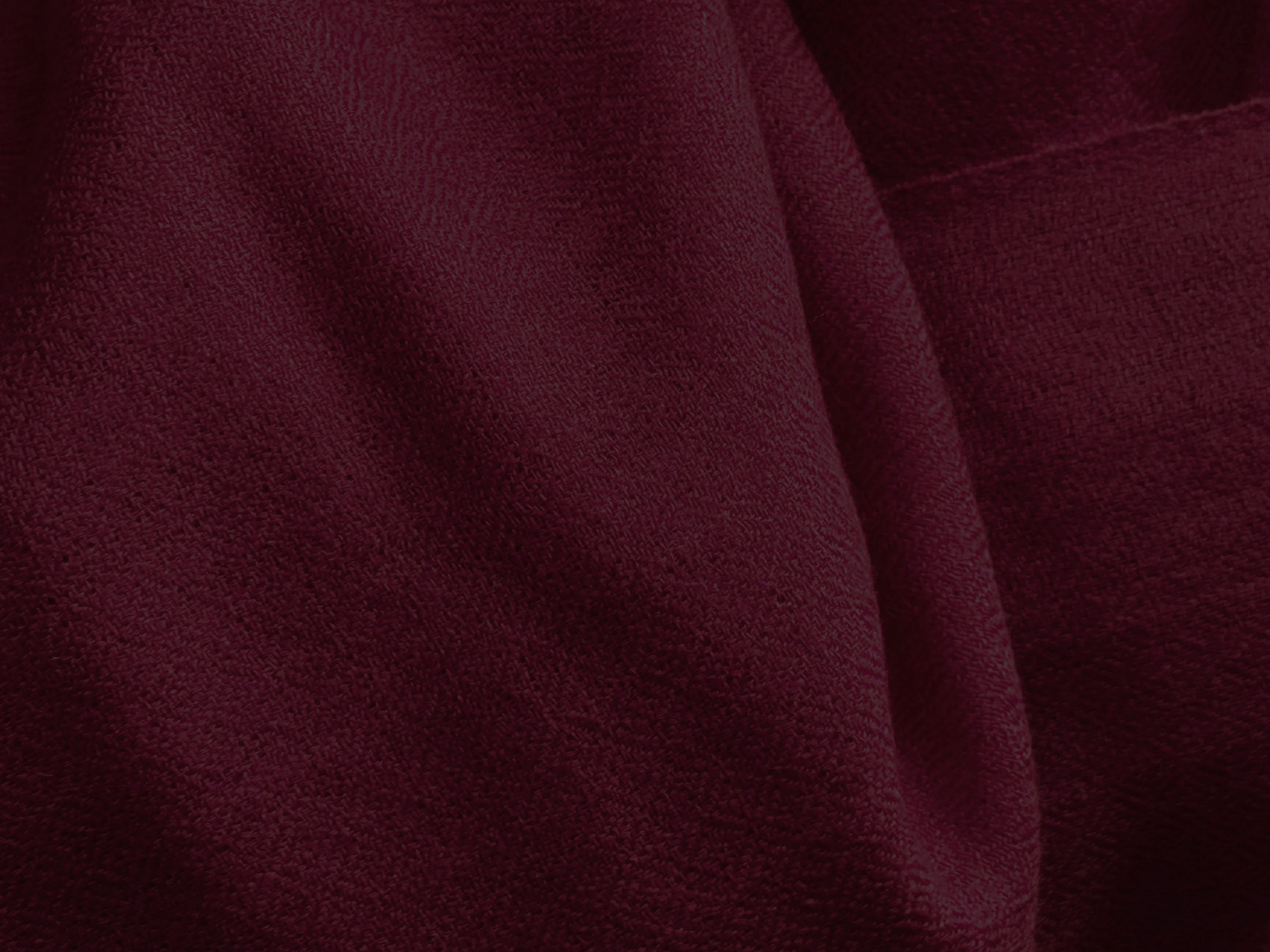 This image showcases a finely textured burgundy merino wool shawl, exuding warmth and elegance. Its soft, luxurious fabric is designed to provide comfort and style, perfect for meditation or casual wear.