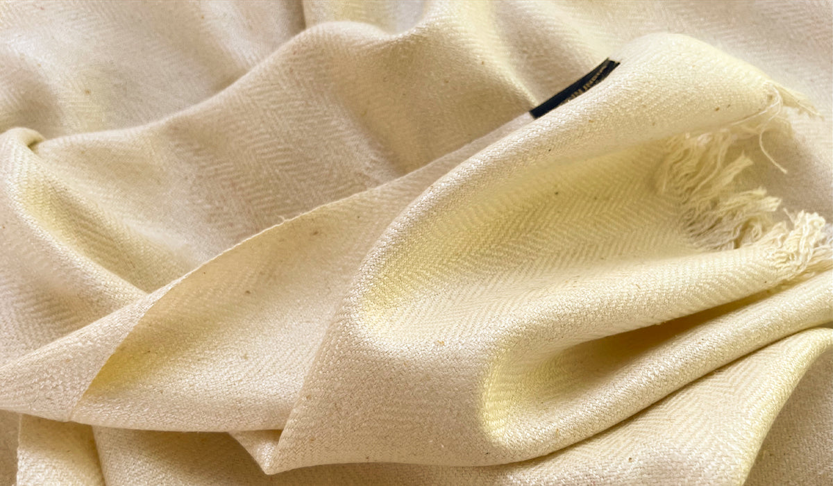 Silk shawl in a creamy color, showing off its smooth finish and premium quality.