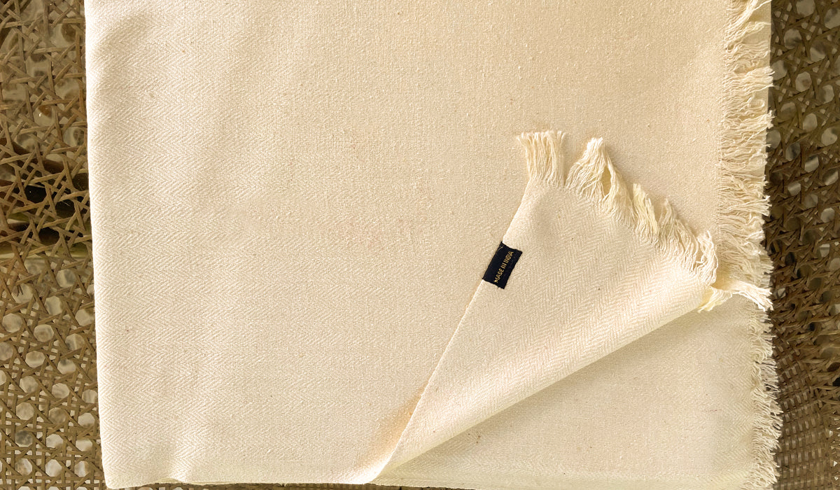 Close-up of a cream shawl, showcasing its smooth texture and elegant weave, perfect for meditation.