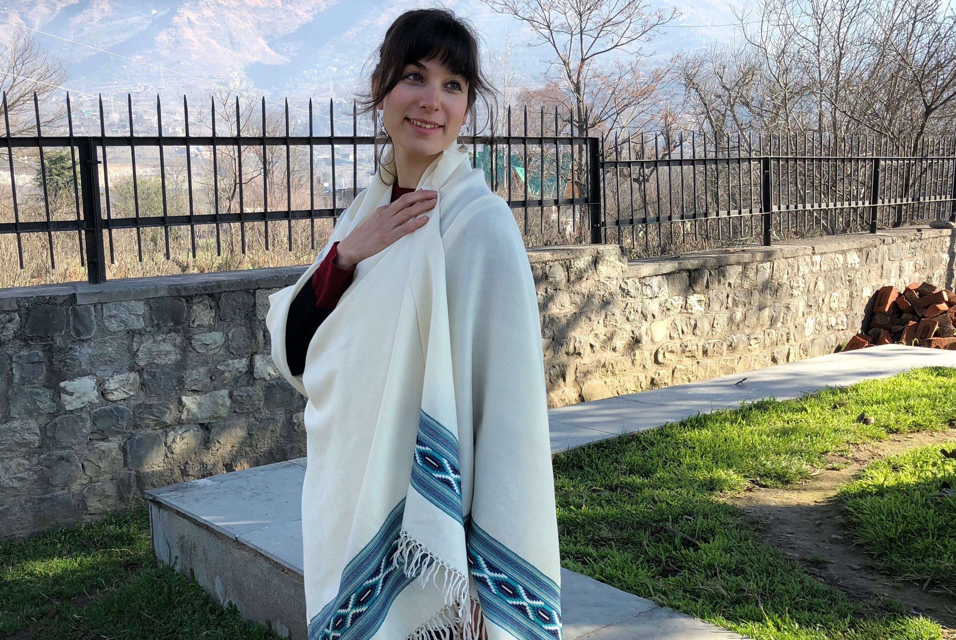 Detailed view of the blue and cream ethnic shawl with traditional patterns, a warm and stylish accessory for meditation.