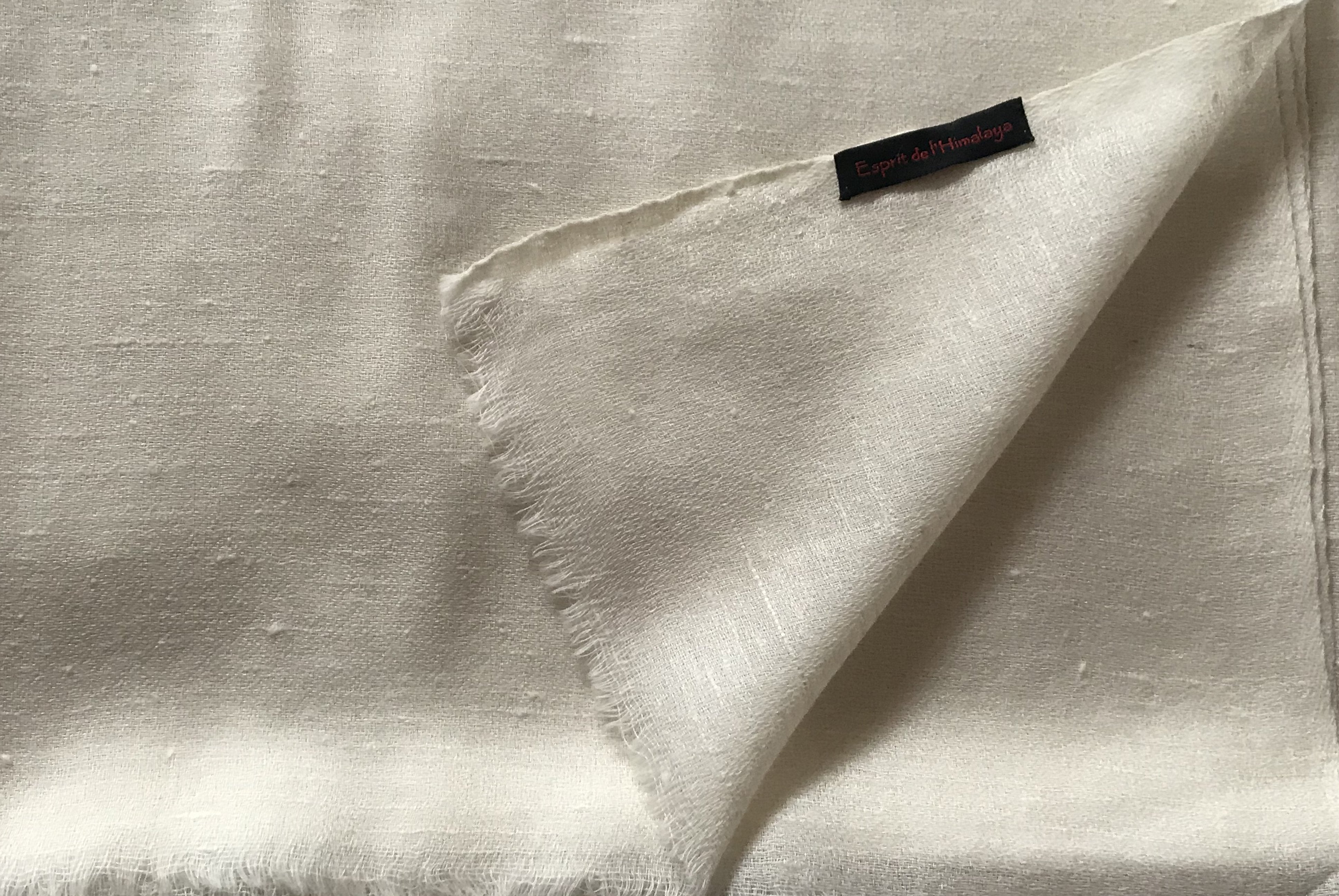 Detailed fabric view of the cream merino wool angora shawl, highlighting its soft texture.