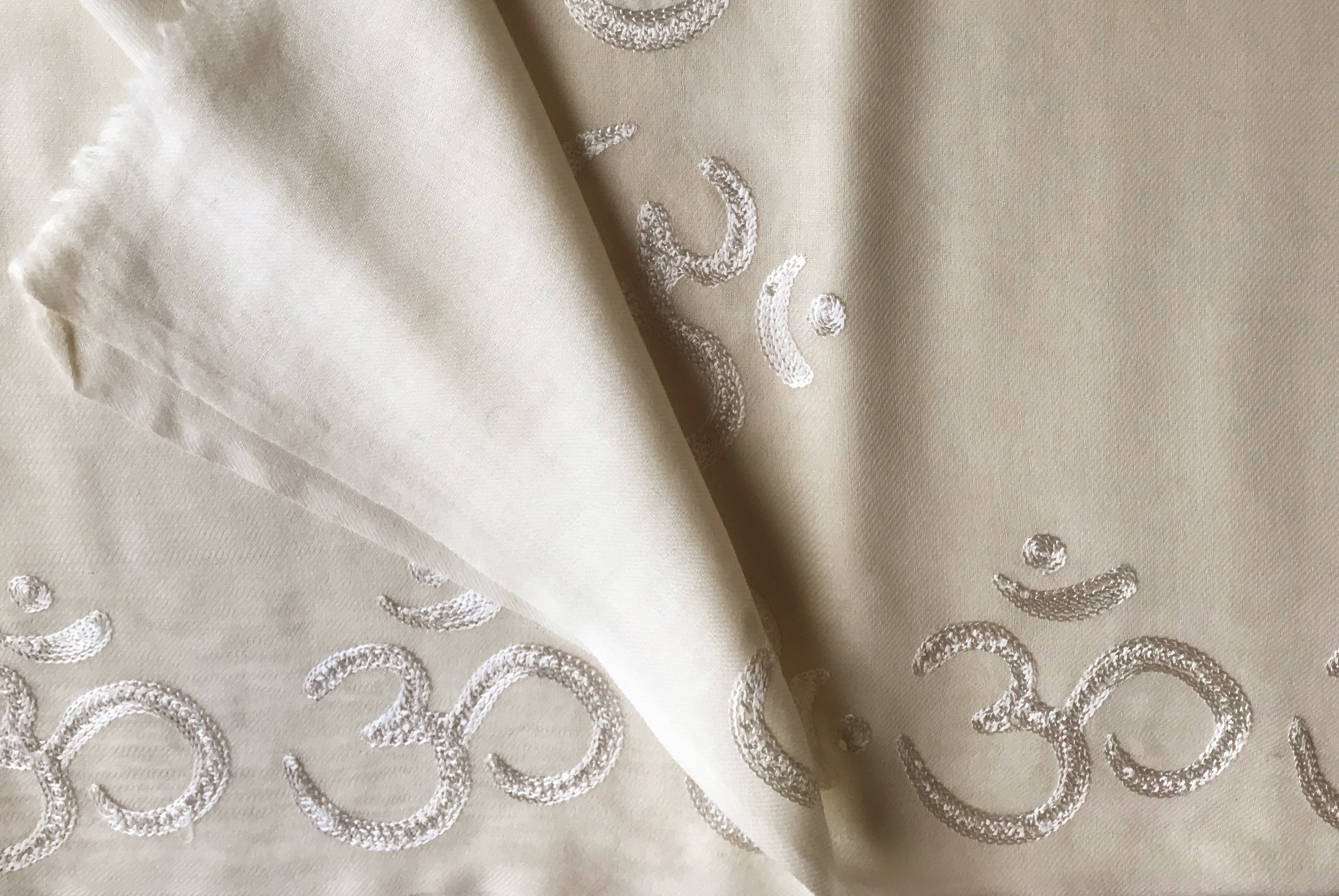 A soft cream-colored yoga blanket, perfect for meditation and relaxation.