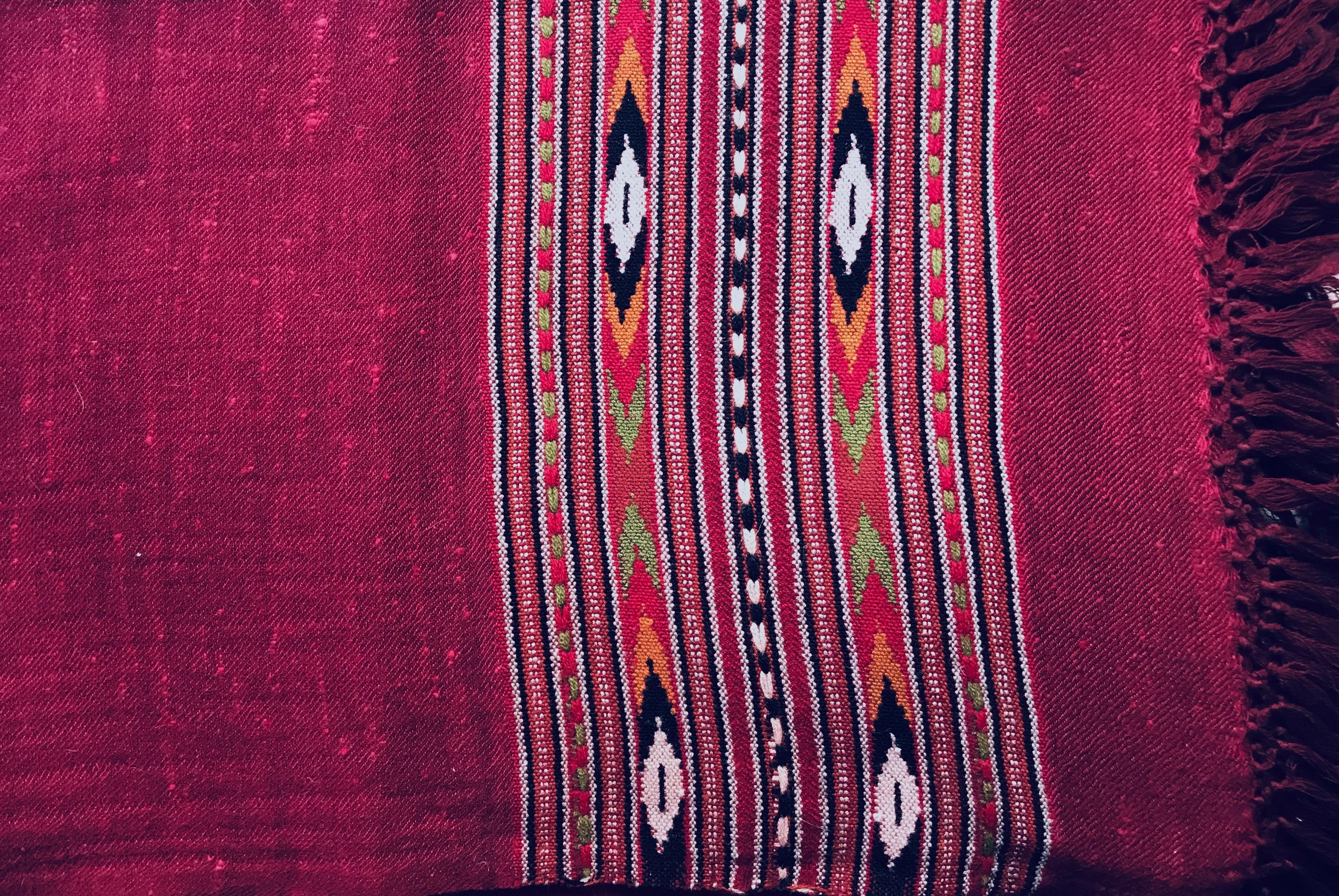 Detailed view of a burgundy and magenta meditation shawl with ethnic patterns, highlighting traditional Indian design elements.