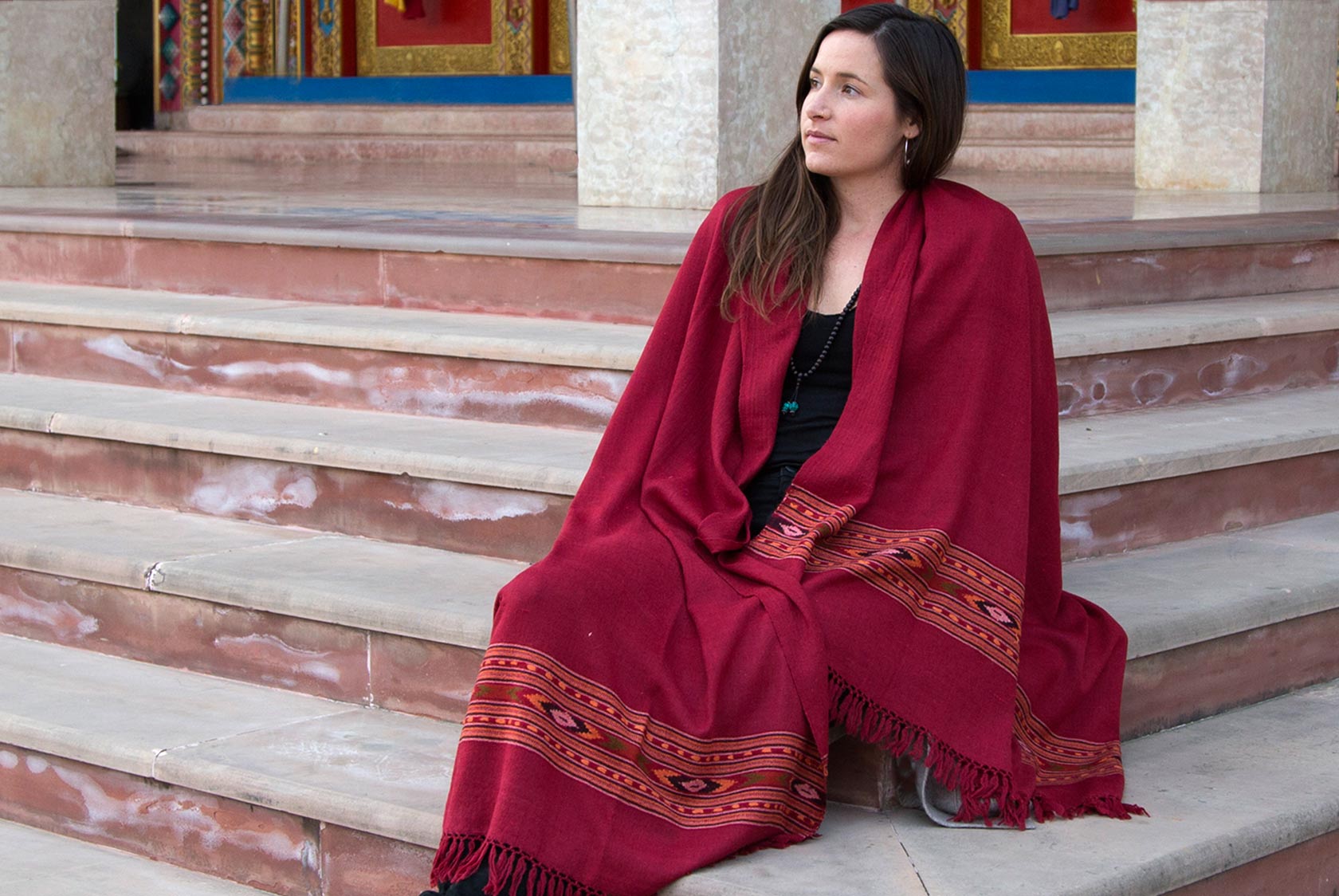 Traditional Indian meditation shawl in deep burgundy red, draped over a person’s shoulders.