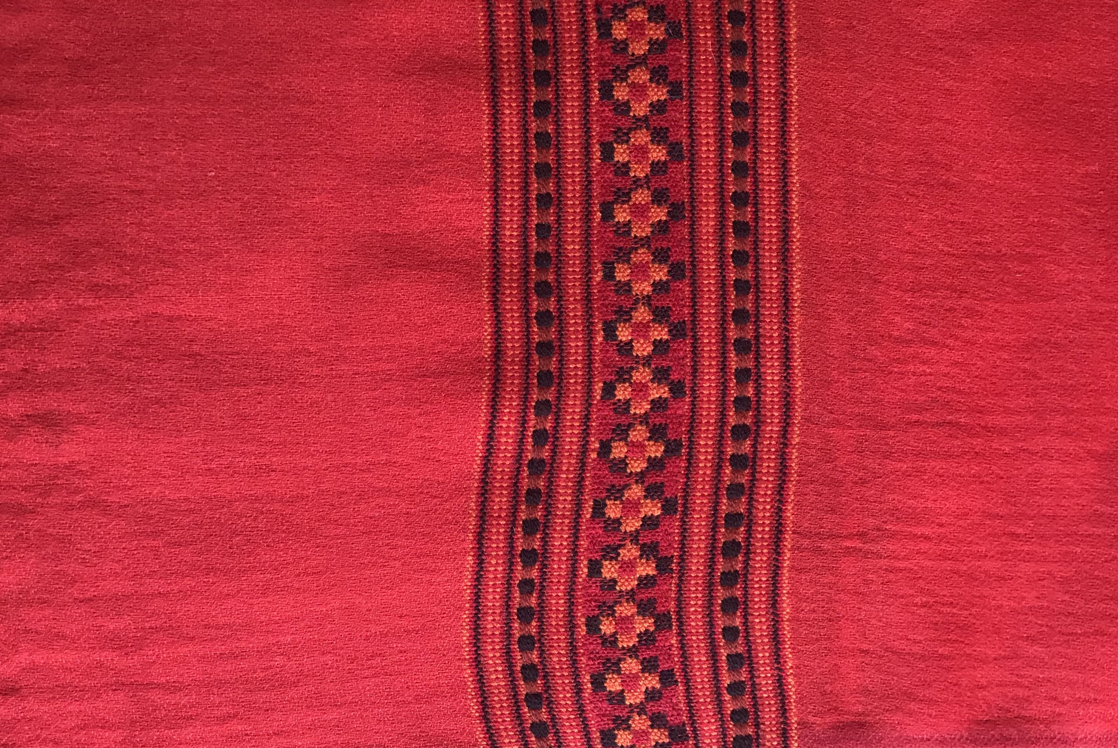 Close-up of Karuna meditation shawl showcasing a red traditional pattern with detailed textures.