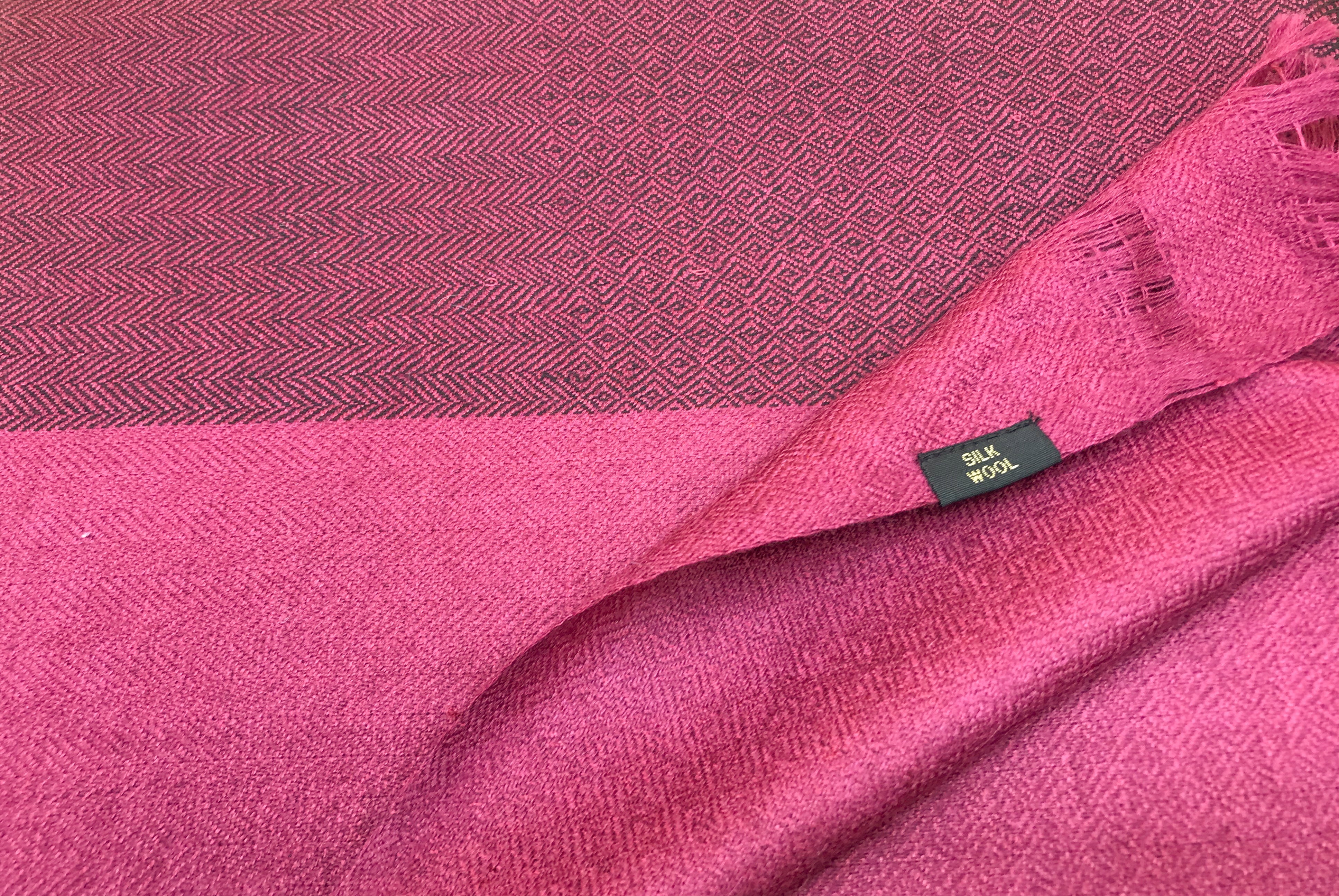 Detailed closeup of the texture and pattern on a magenta handwoven meditation shawl.