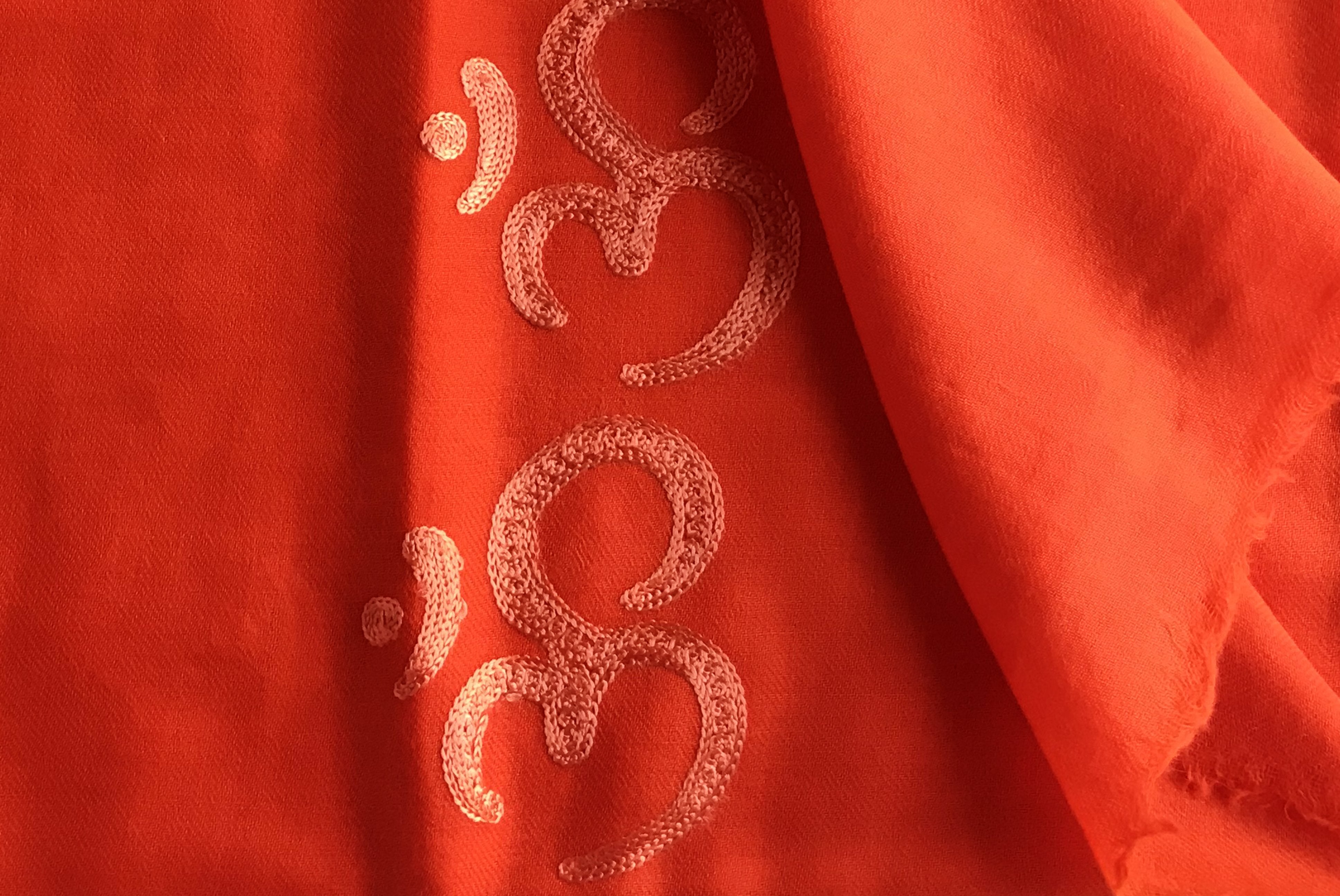 Orange OM yoga blanket, highlighting the soft texture and vibrant color.