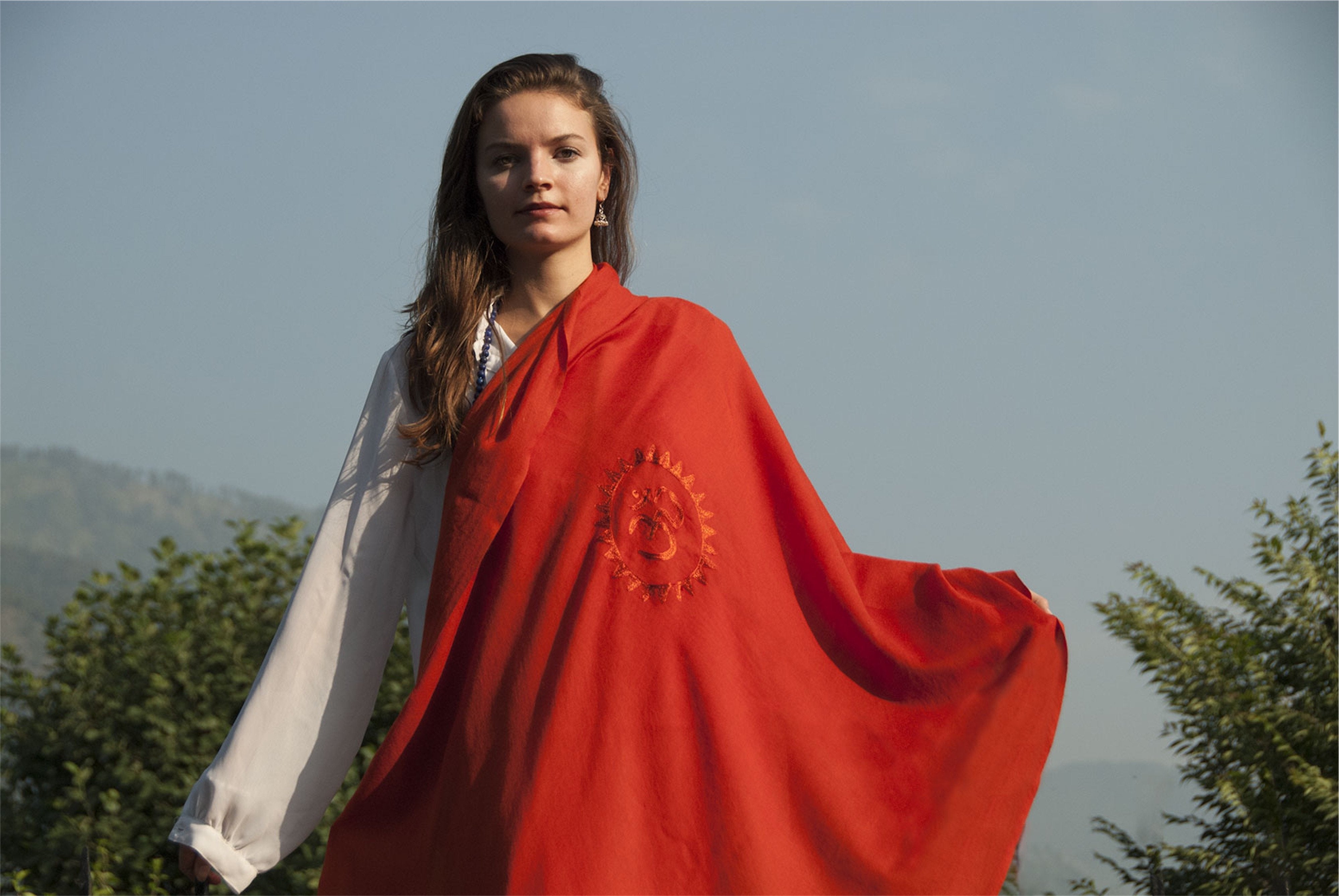 A meditation shawl with Om symbol in red fabric.